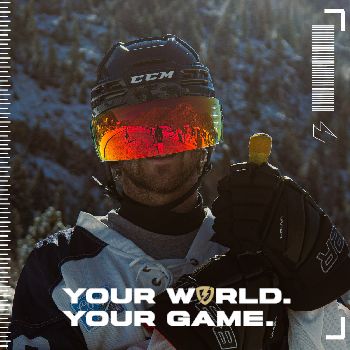 Person wearing a hockey helmet with an inferno SHOC Hockey Visor with a snowy landscape in the background, featuring the text 'Your World. Your Game.'